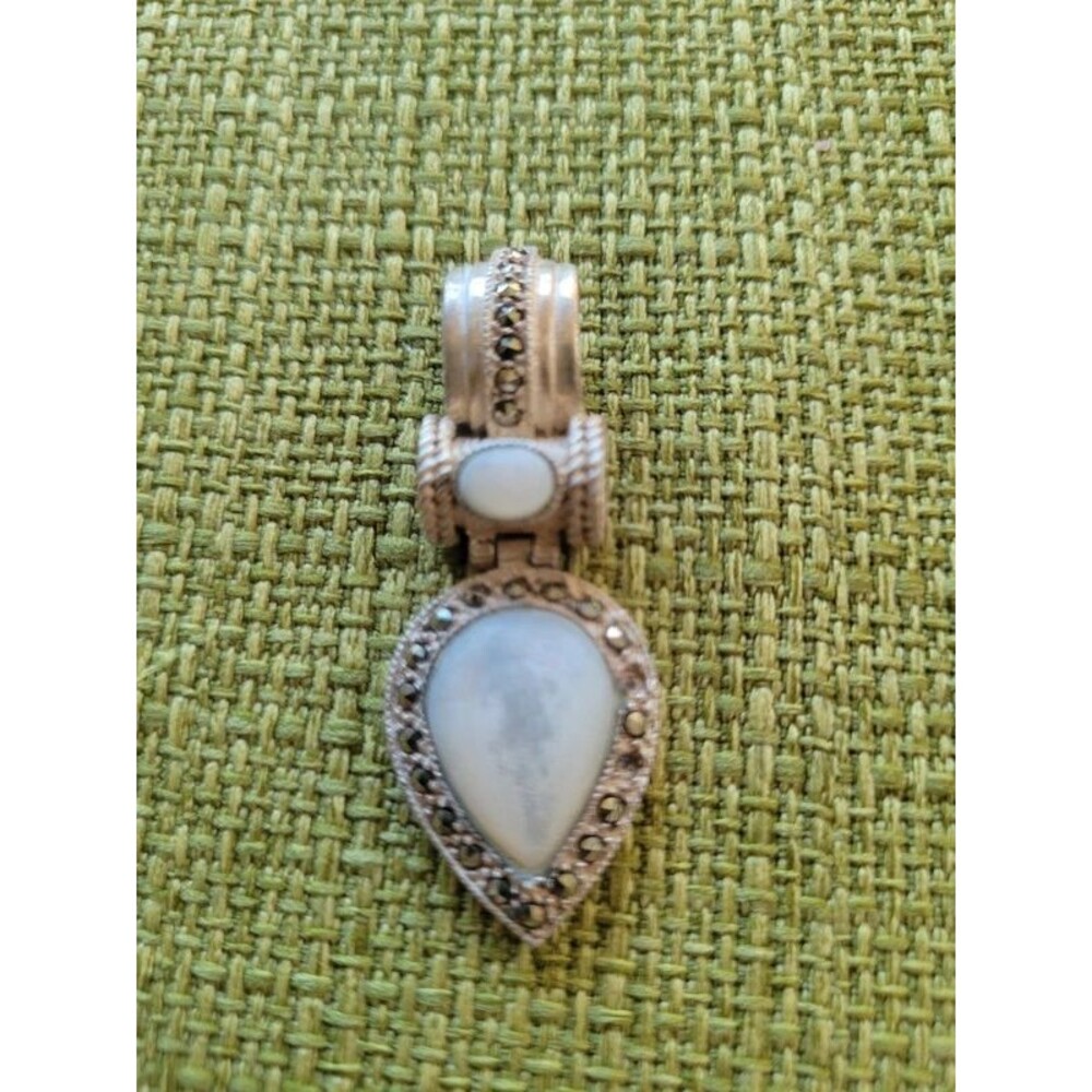 Large sterling silver and marcasite pendant with white stone.